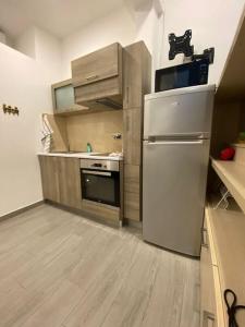 a small kitchen with a refrigerator and a sink at NINA, a centrally located summery studio apartment in Il-Gżira