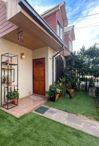 dom z drewnianymi drzwiami i zieloną trawą w obiekcie Casa Talca w mieście Talca