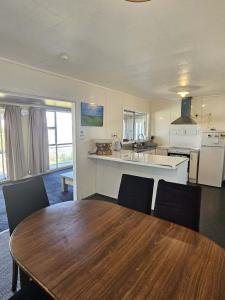 a kitchen and dining room with a wooden table and chairs at Aorangi Peak Cottage in Rotorua