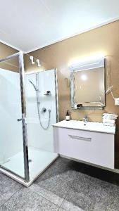 a bathroom with a shower and a sink with a mirror at Aorangi Peak Cottage in Rotorua