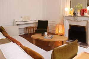een woonkamer met een bank en een piano bij Spacious haussmann apartment in Parijs
