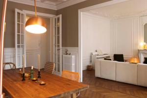 een woonkamer met een houten tafel en een bank bij Spacious haussmann apartment in Parijs