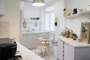 een keuken met witte kasten en een tafel en stoelen bij Spacious haussmann apartment in Parijs