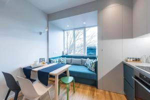 uma cozinha com um sofá azul e uma mesa e cadeiras em Modern & Stylish Sea Apartment with Parking em Burgas