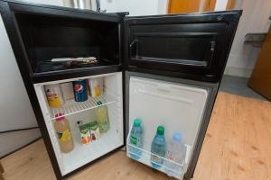 - un réfrigérateur avec une porte ouverte et des boissons dans l'établissement Citea Access 10 minutes La Defense - 20 minutes Paris Parc Expo, à Saint-Cloud