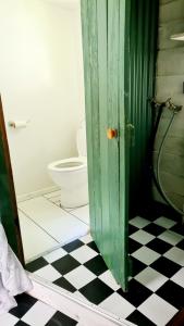 a bathroom with a green door and a toilet at Truffle Honey Cottage in Warkworth