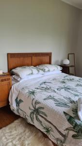 a bedroom with a large bed with a wooden headboard at Truffle Honey Cottage in Warkworth