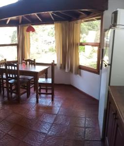 ein Esszimmer mit einem Tisch, Stühlen und Fenstern in der Unterkunft Cabañas Mar Azul in Mar Azul