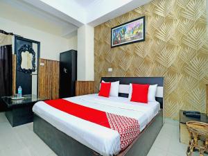 een slaapkamer met een groot bed met rode kussens bij OYO Flagship Welcome Lounge in Shāhpur