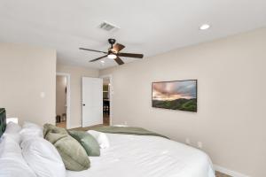 1 dormitorio con 1 cama blanca y ventilador de techo en The Dewberry, en Houston