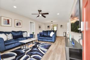 sala de estar con sofás azules y ventilador de techo en The Dewberry, en Houston