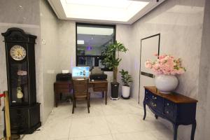 an office with a desk and a clock and a vase of flowers at JB Tourist Hotel in Daegu