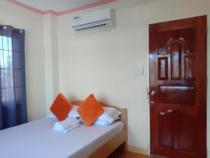 a bedroom with a bed with orange pillows on it at Friz Love Room Rental in San Juan