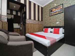 een slaapkamer met een bed met rode kussens en een bank bij OYO Flagship Welcome Lounge in Shāhpur