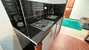 a kitchen with a stove and a sink at Apartaestudio Aguamarina in Líbano