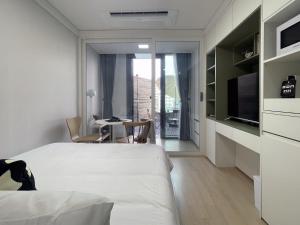 una camera con letto, scrivania e TV di Urbanstay Myeongdong a Seul
