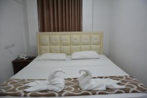 ein Bett mit zwei Schwänen aus Handtüchern in der Unterkunft Saasha City Hotel in Colombo