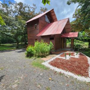 una pequeña casa de madera con techo rojo en Cabaña del Lago, en Cuatro Esquinas