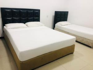 two twin beds in a room with at Saasha City Hotel in Colombo