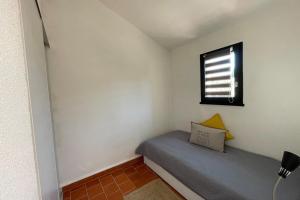 a small bedroom with a bed and a window at Charming Mazet ideal for families swimming pool tennis in Maussane-les-Alpilles