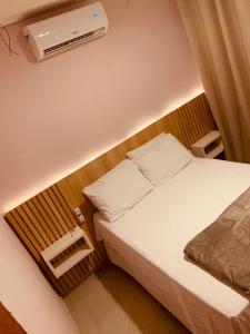 a small bedroom with a bed and a air conditioner at Sol de Corumbau in Corumbau +49 photos