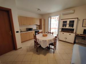 une cuisine avec une table et des chaises ainsi qu'une cuisine avec une table et une table dans l'établissement SMERALDA, à Alghero