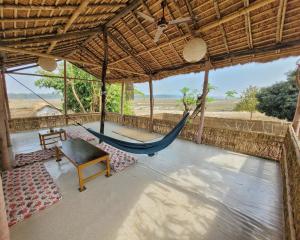um alpendre com uma rede de descanso e uma mesa em Ishq Sanctum- A Conscious Guest House em Bhagaura