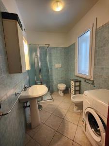 La salle de bains est pourvue d'un lavabo et d'un lave-linge. dans l'établissement SMERALDA, à Alghero
