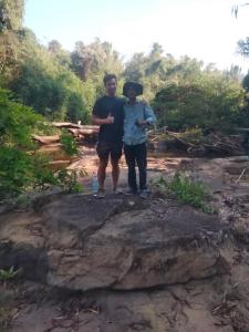 Ein Mann und ein Junge stehen auf einem Felsen in der Unterkunft Ratanakiri Lakeside Homestay & Tours in Banlung