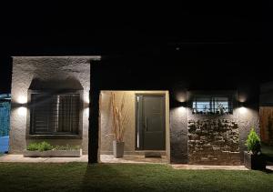 una casa con una puerta verde y ventanas por la noche en Casa "La Margarita" - Villa 25 de Mayo, San Rafael en San Rafael