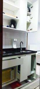 a kitchen with white cabinets and a sink at Quitinete ACONCHEGANTE in Rio de Janeiro