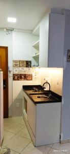 uma cozinha com um lavatório e um fogão forno superior em Quitinete ACONCHEGANTE no Rio de Janeiro