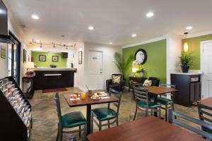 un restaurante con paredes verdes, mesas y sillas en Rodeway Inn San Jose HWY-101 Tully Rd Exit, en San José