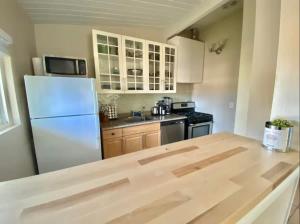 a kitchen with a white refrigerator and a stove at West Beach Treehouse in Santa Barbara
