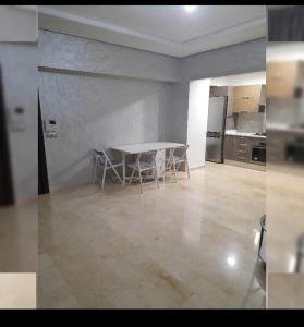 uma cozinha com mesa e cadeiras num quarto em ايربان بلاص em Casablanca