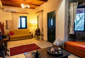 uma sala de estar com um sofá e uma porta em Marianda's House - Mountain Views & Rustic Charm em Tíkhion