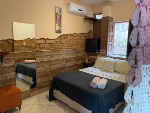 ein Hotelzimmer mit 2 Betten und einem TV in der Unterkunft Hospedaria do Tom in Lençóis