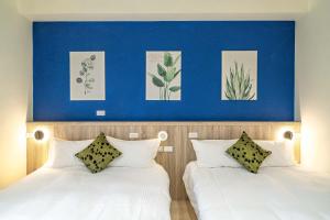 2 camas en un dormitorio con una pared azul en 田園走走 en Jiaoxi