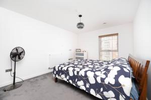 a bedroom with a bed and a fan at Stylish 1BR Flat with Balcony Near Tube and Shops in Woolwich