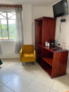 ein Wohnzimmer mit einem Stuhl und einem TV in der Unterkunft Casa Lolita in Xilitla