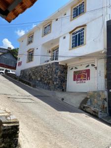 ein weißes Gebäude an der Seite einer Straße in der Unterkunft Casa Lolita in Xilitla