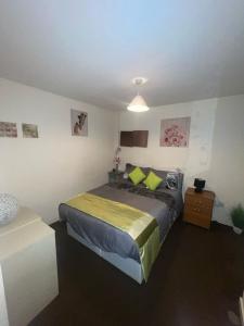 a bedroom with a bed with green pillows at Lovely double room with private bathroom and Double room with shared toilet & PARKING FREE in Edinburgh