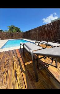 una mesa de picnic en una terraza junto a una piscina en The Olive House PR, en Río Grande