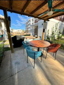 Una mesa y sillas de madera en un patio. en Departamento Planta Baja, A 1 Minuto de la playa., en Mazatlán