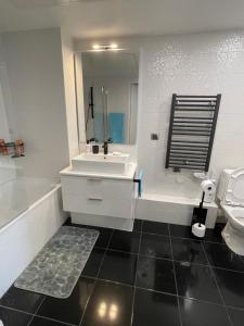 a white bathroom with a sink and a mirror at PRADO PLAGE DAVID - MARINA OLYMPIQUE JO 2024 - STADE VELODROME - PARC BORELY - LA CORNICHE- CLUB NAUTIQUE - appartement situé à 800m de JO 2024 et à 10m de plage -Luxury apartment by the Sea in Marseille