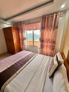 a bedroom with a large bed and a window at New Way Hotel in Cat Ba