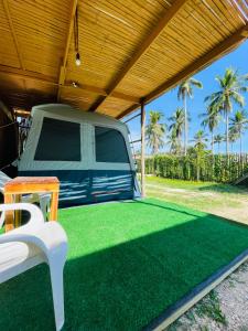 a truck parked under a cover with green grass at Russell Place Tent in Port Barton