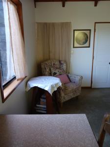 a room with a couch and a chair and a window at The Annex in Whitianga