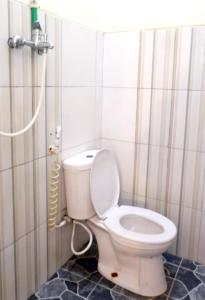 ein Badezimmer mit einem weißen WC in einer Kabine in der Unterkunft Samudra Hotel in Jepara