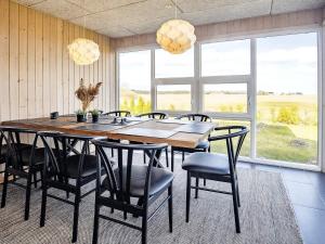a dining room with a large wooden table and chairs at 10 person holiday home in Hals in Hou